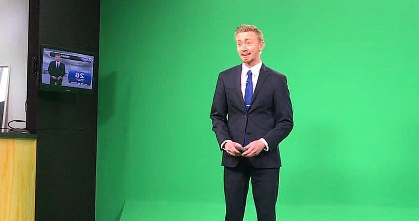 Meteorologist Josh Cozart stands in front of a green screen