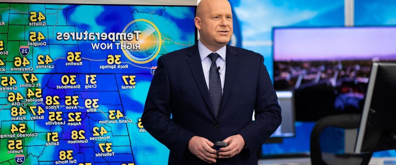 Broadcast meteorologist Chris Spears stands in front of a weather map